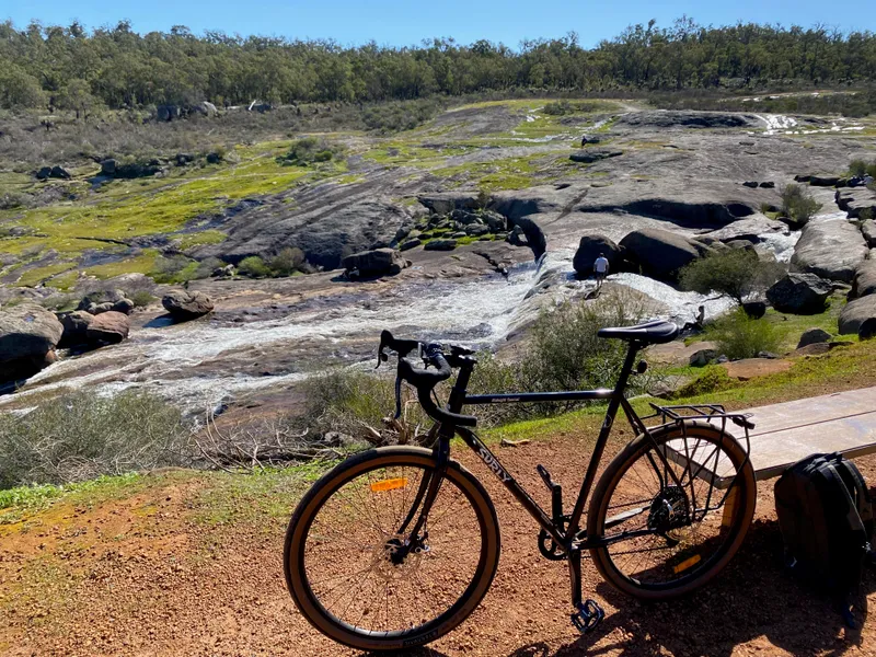A gravel bike parked in front of a water fall